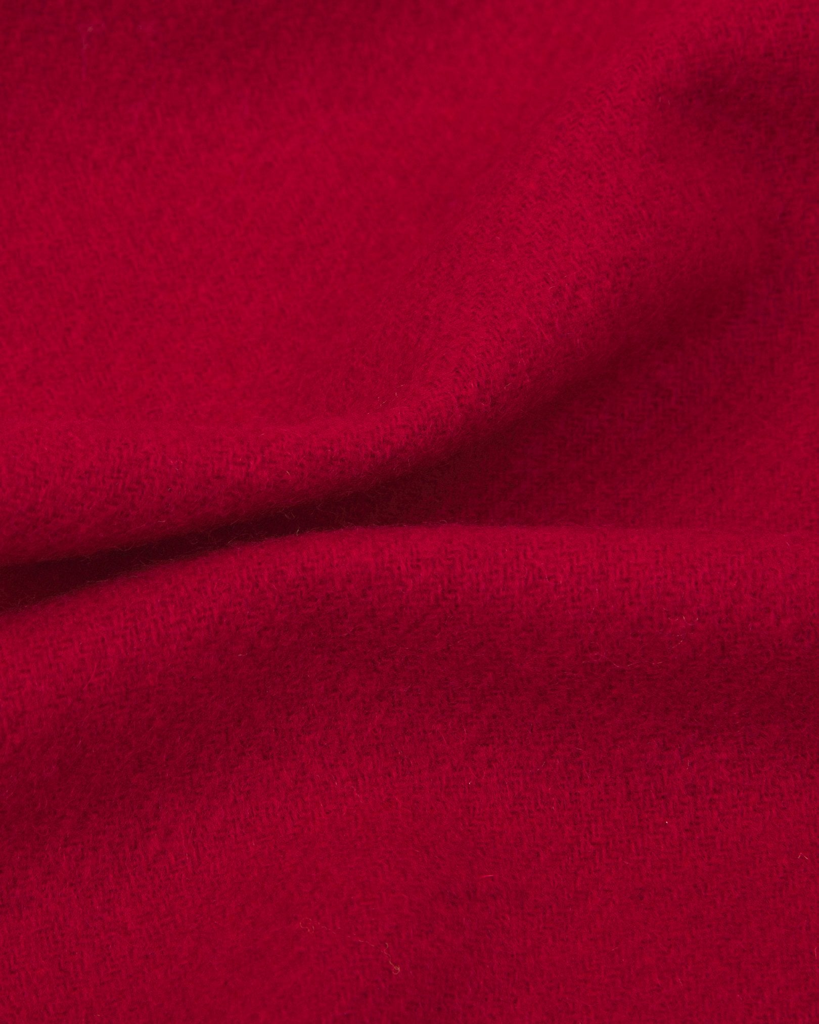 Ruffled close-up view of the UK-made, pure Merino wool 'lowlands' tartan dress in scarlet-red scarf, presenting a closer view of the premium woollen fabric.