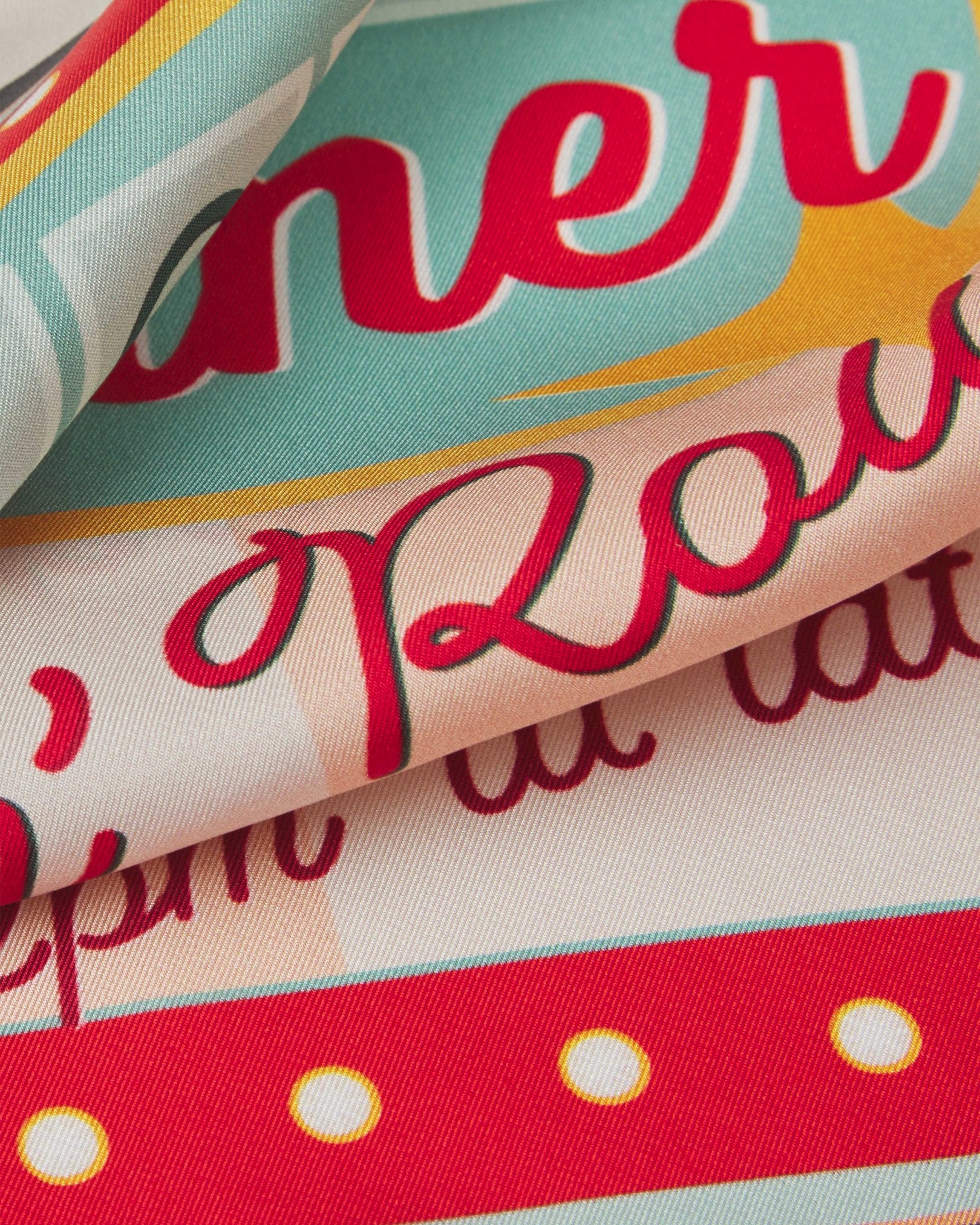 A ruffled close-up of the 'Milkshake' on chalk silk pocket square, presenting a closer look at a portion of the diner signage design.