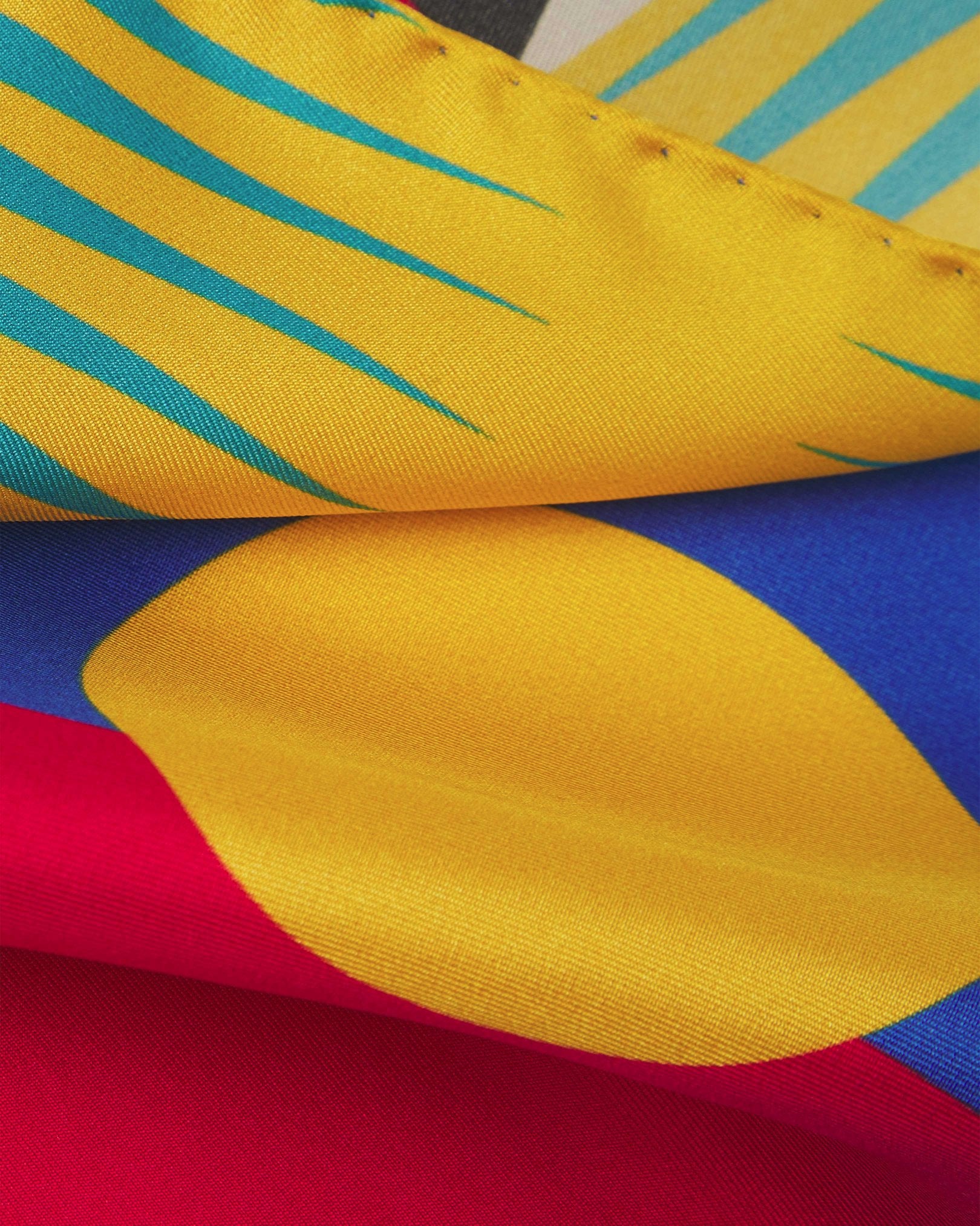 A ruffled close-up of the 'Munich' pocket square, presenting a closer view of the brightly coloured Bauhaus inspired patterns.