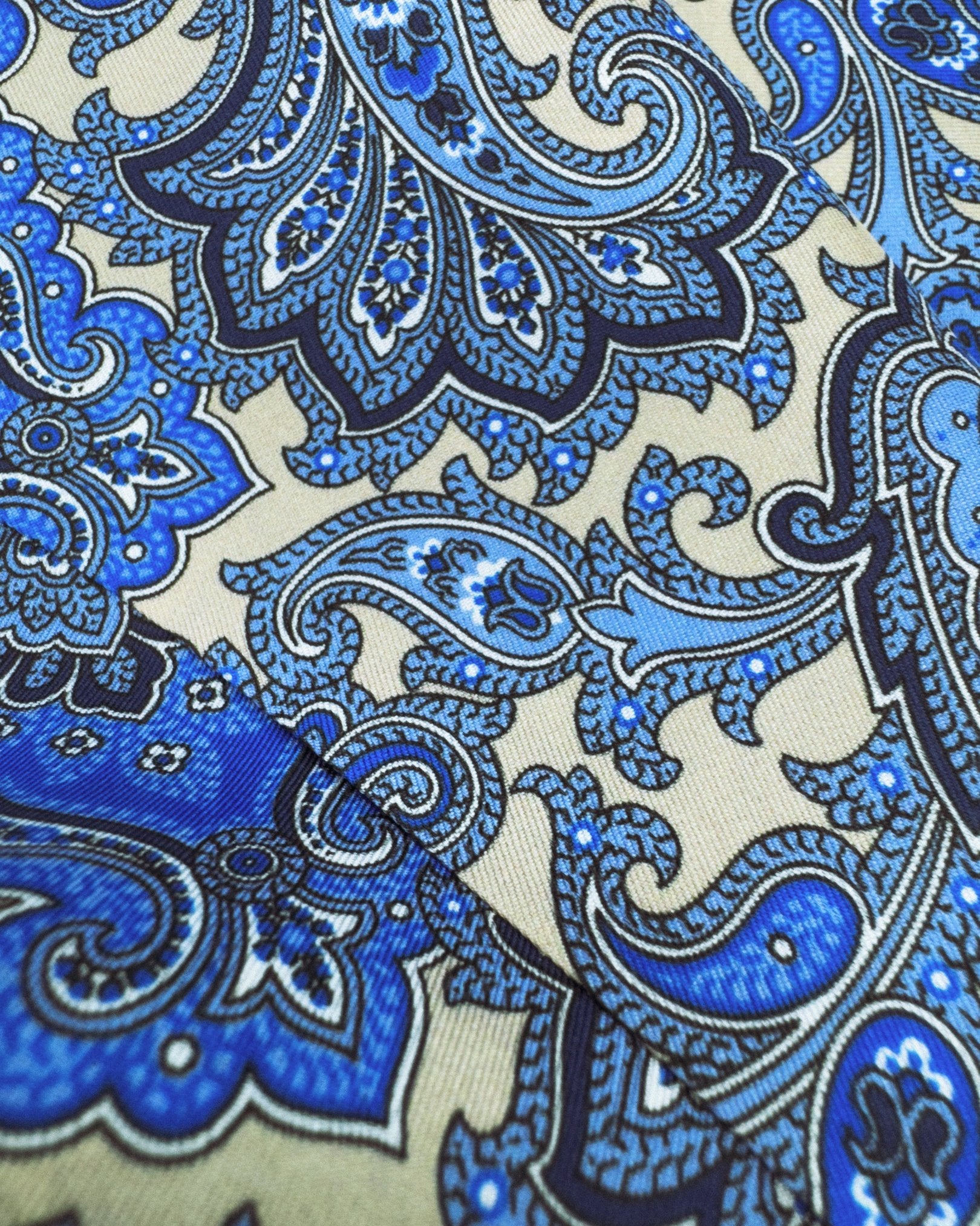 A closer, ruffled view of fawn patterned scarf, focussing on the various blue paisley and floral-inspired patterns.