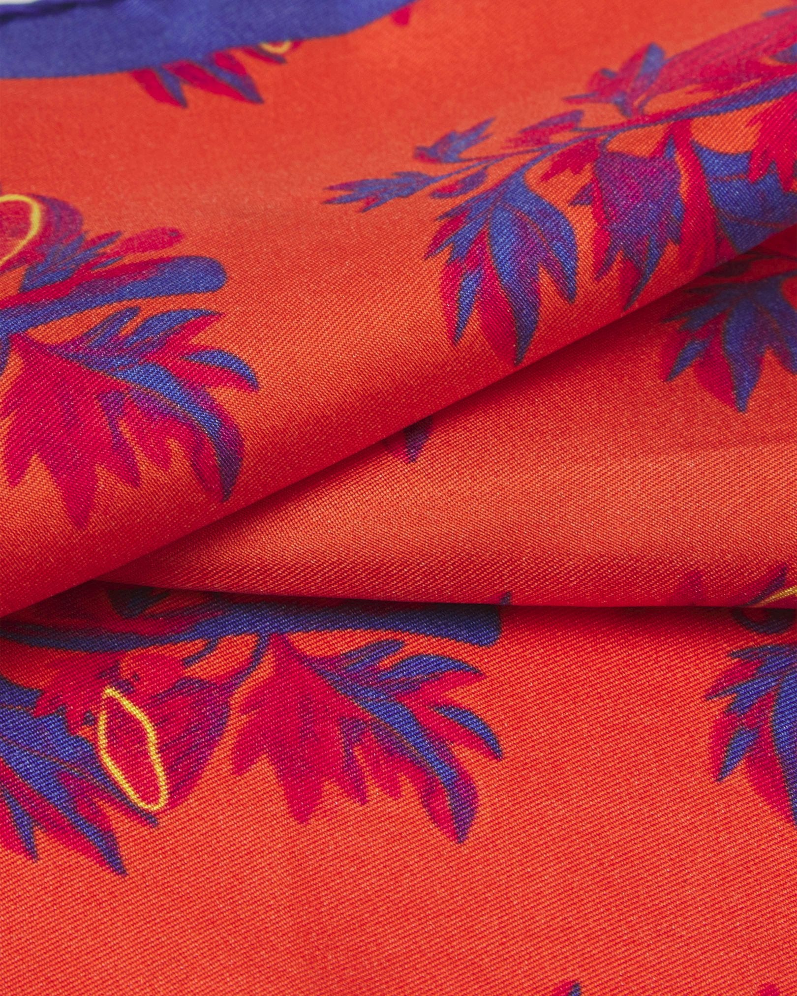 A ruffled close-up of the 'Severn' silk pocket square from SOHO Scarves, showing overlapping elements of the stylised tree branch repeat motif.