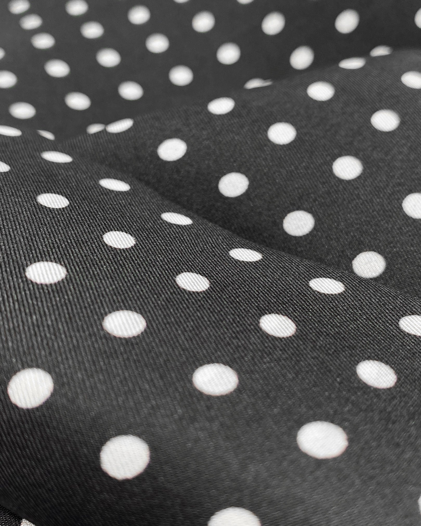 Ruffled close-up view of the 'Shinagwa' silk aviator scarf, presenting a closer view of the white polka dot pattern and subtle lustre of the material.