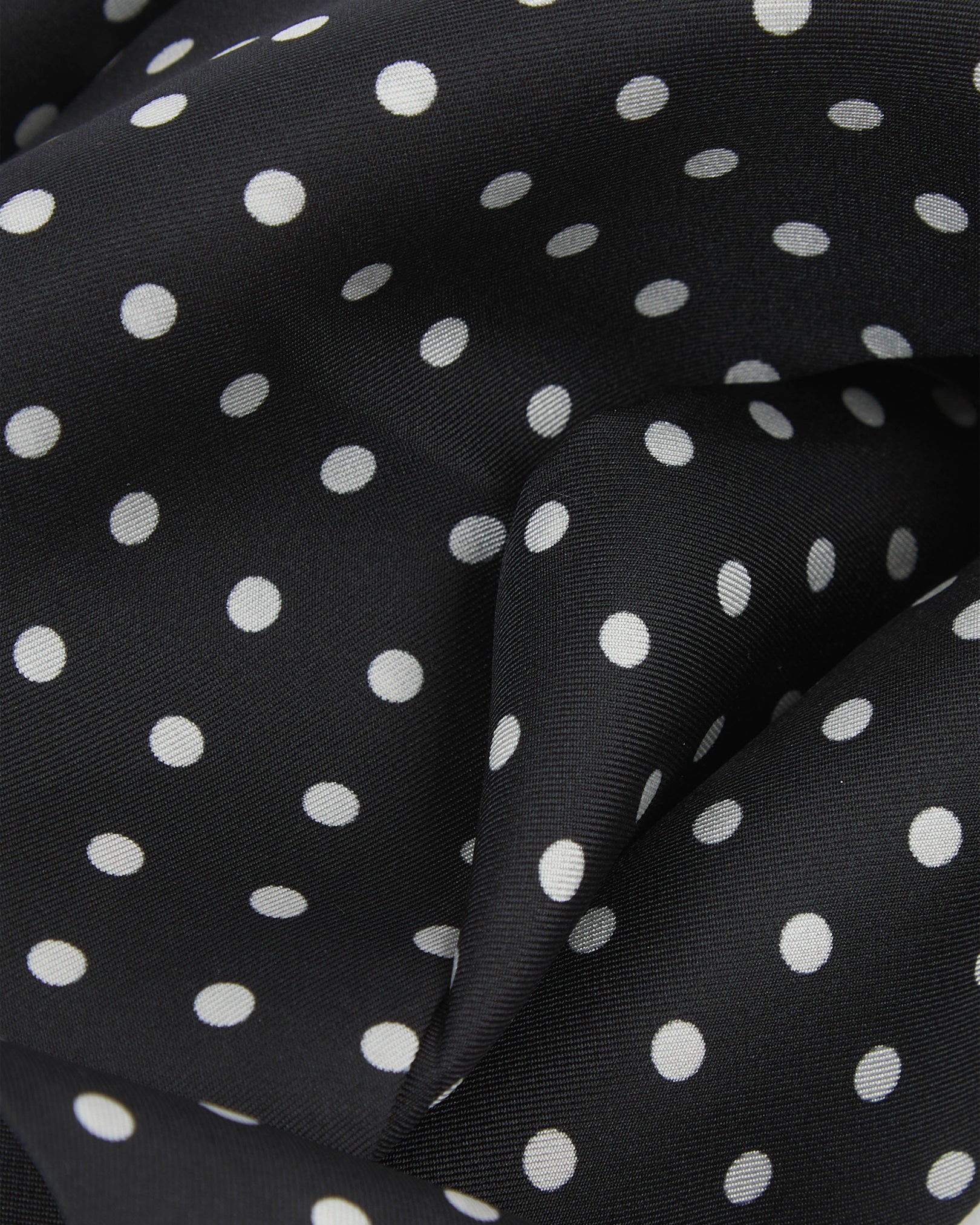 Ruffled close-up view of the 'Shinagwa' silk scarf, presenting a closer view of the white polka dot pattern and subtle lustre of the material.