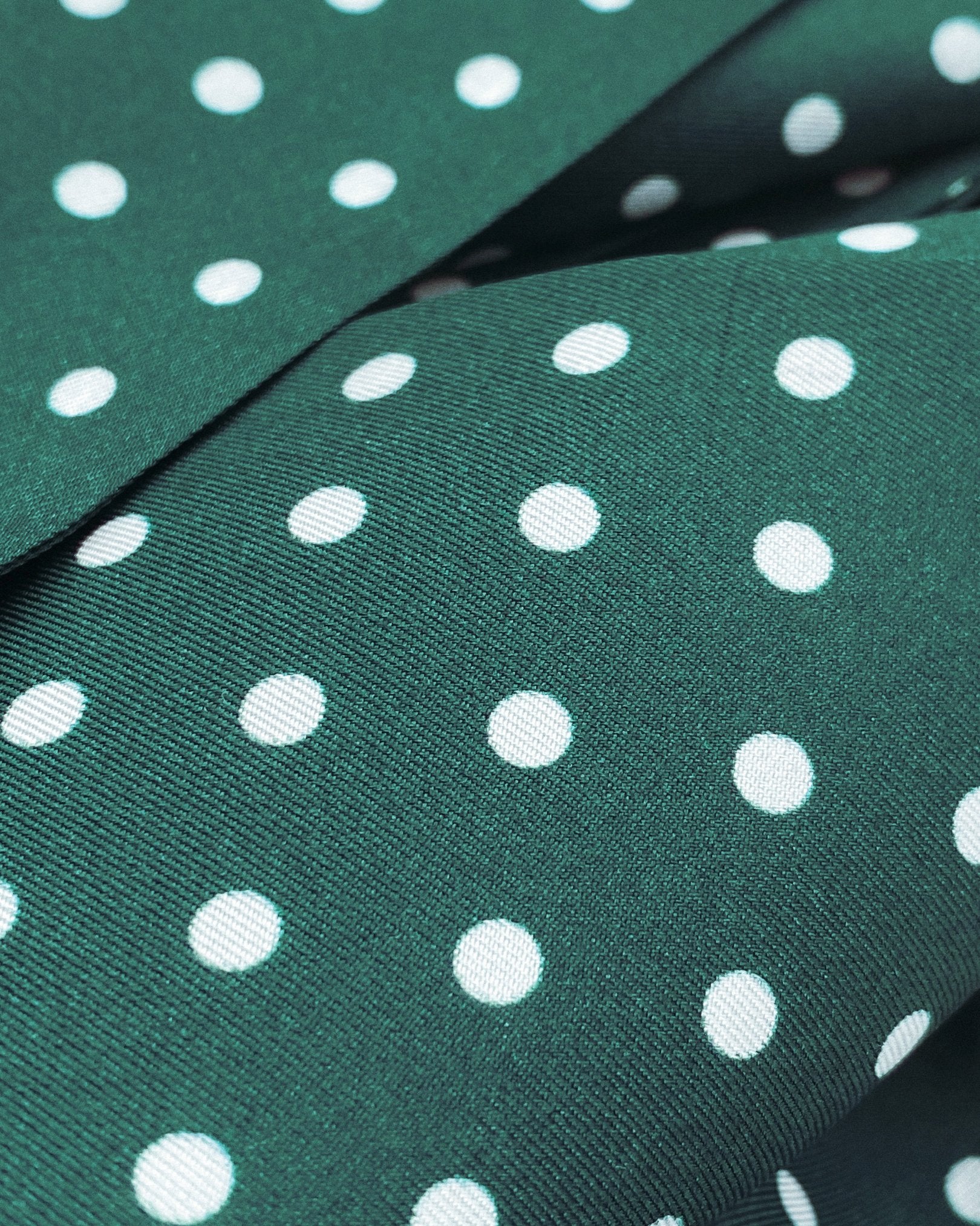 A flat and ruffled view of the 'Westminster Rg' silk aviator scarf presenting a closer view of the silk fabric and the white polka-dot patterns.