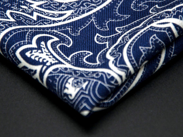 Close-up of a quarter point of the 'Kakumae' dark blue pocket square, providing clear view of the wool weave and an even closer look at a paisley segment.