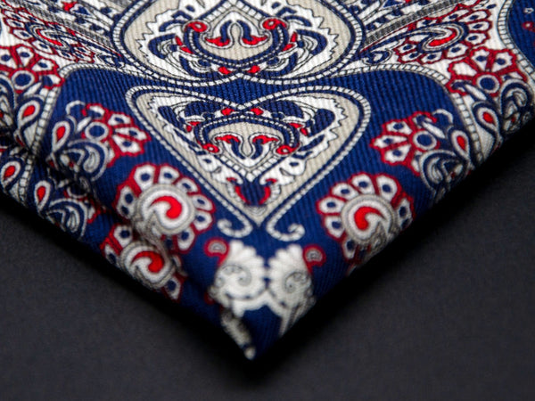 Close-up of a quarter point of the 'Pirita' dark blue pocket square, providing clear view of the wool weave and an even closer look of a paisley segment.