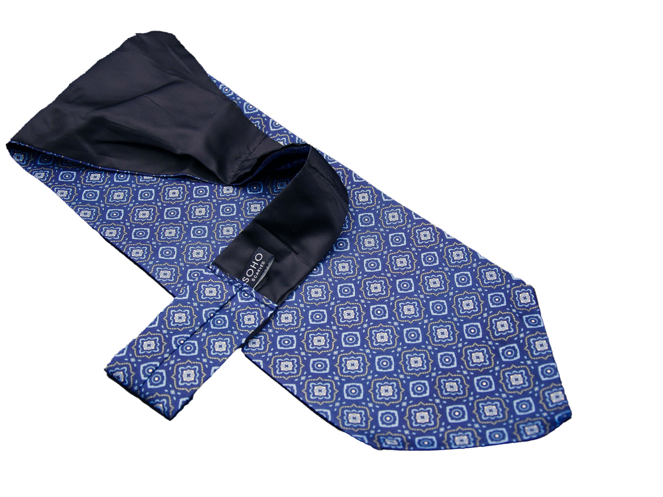 Blue 'Seville' single pointed Ascot tie arranged diagonally with wide point in foreground and clear view of pale blue motifs made up of offset floral-inspired diamond patterns with golden accents.