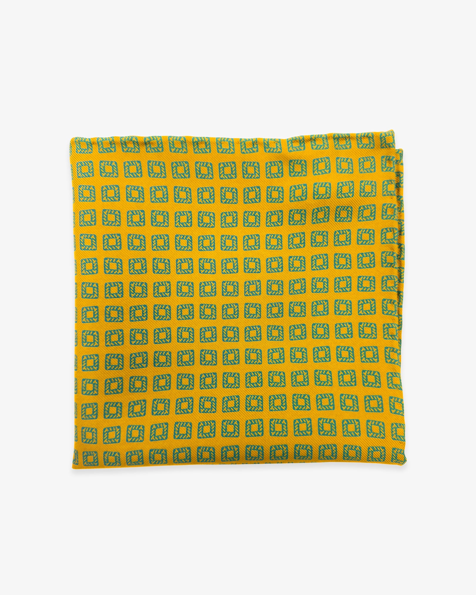 The 'Dover' silk pocket square from SOHO Scarves UK collection. Folded into a quarter, showing the individual blue squares against a gold background.