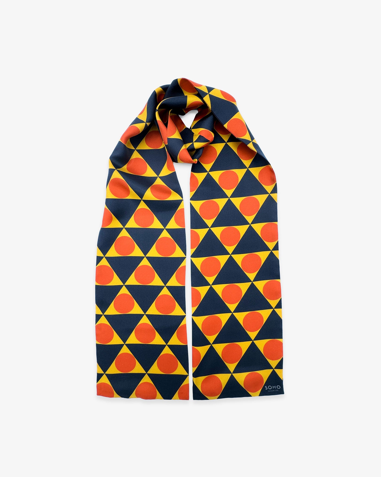 The 'Dresden' Bauhaus-inspired silk scarf looped with both ends parallel to effectively display the full repeat pattern of yellow, charcoal and orange triangular and circular forms.
