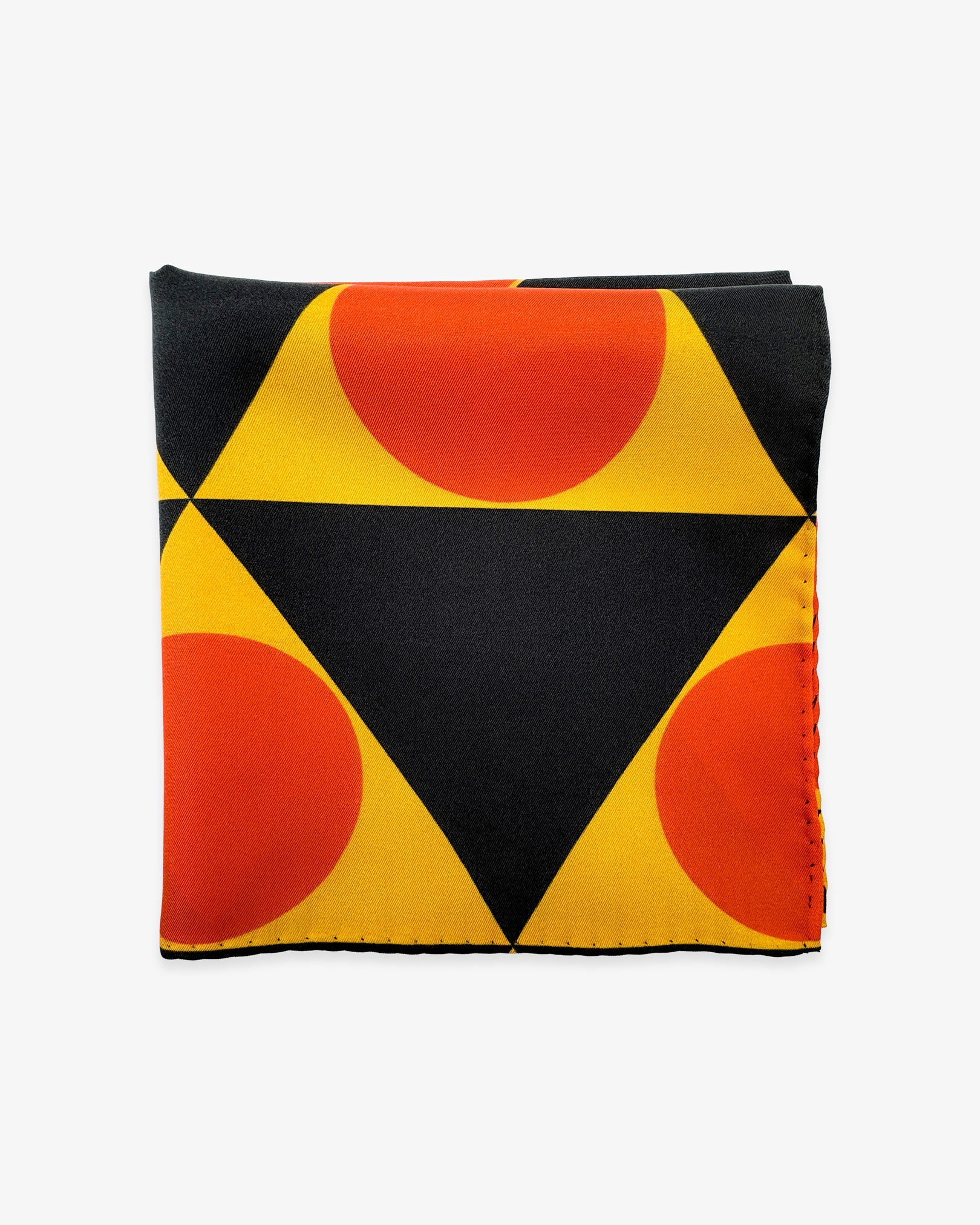 The 'Dresden' silk pocket square from SOHO Scarves folded into a quarter, showing a portion of the bauhaus-inspired triangular and circular repeat patterns.