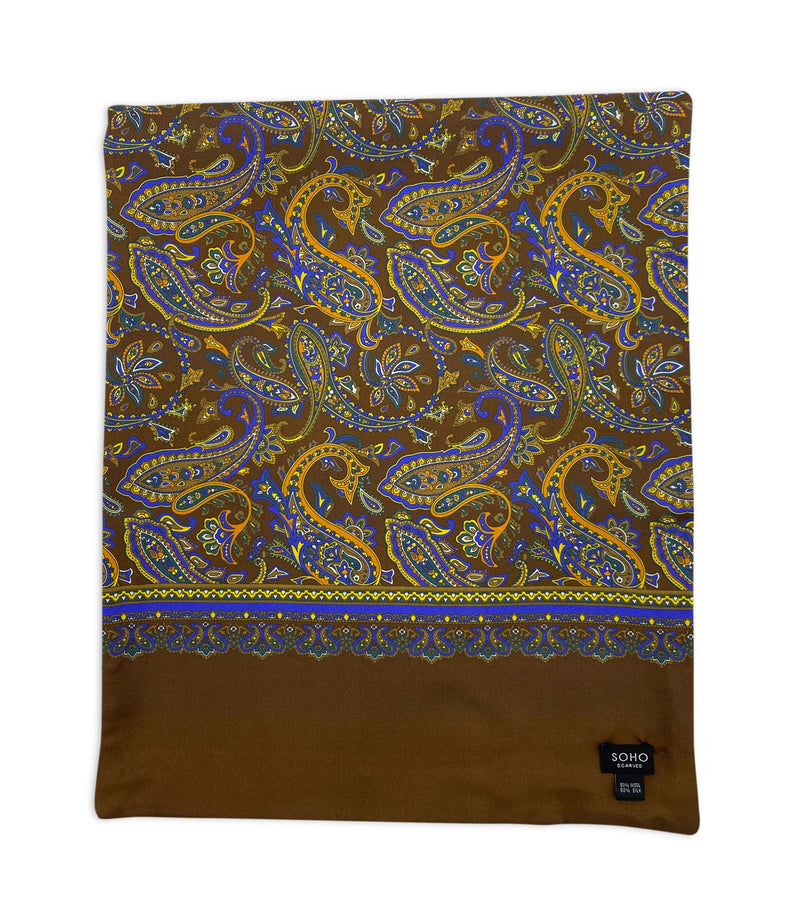 'The Whistler Wide' arranged in a square shape showing the array of paisley patterns on a rich brown background along with the intricate border. Also showing the 'SOHO Scarves' branding label.