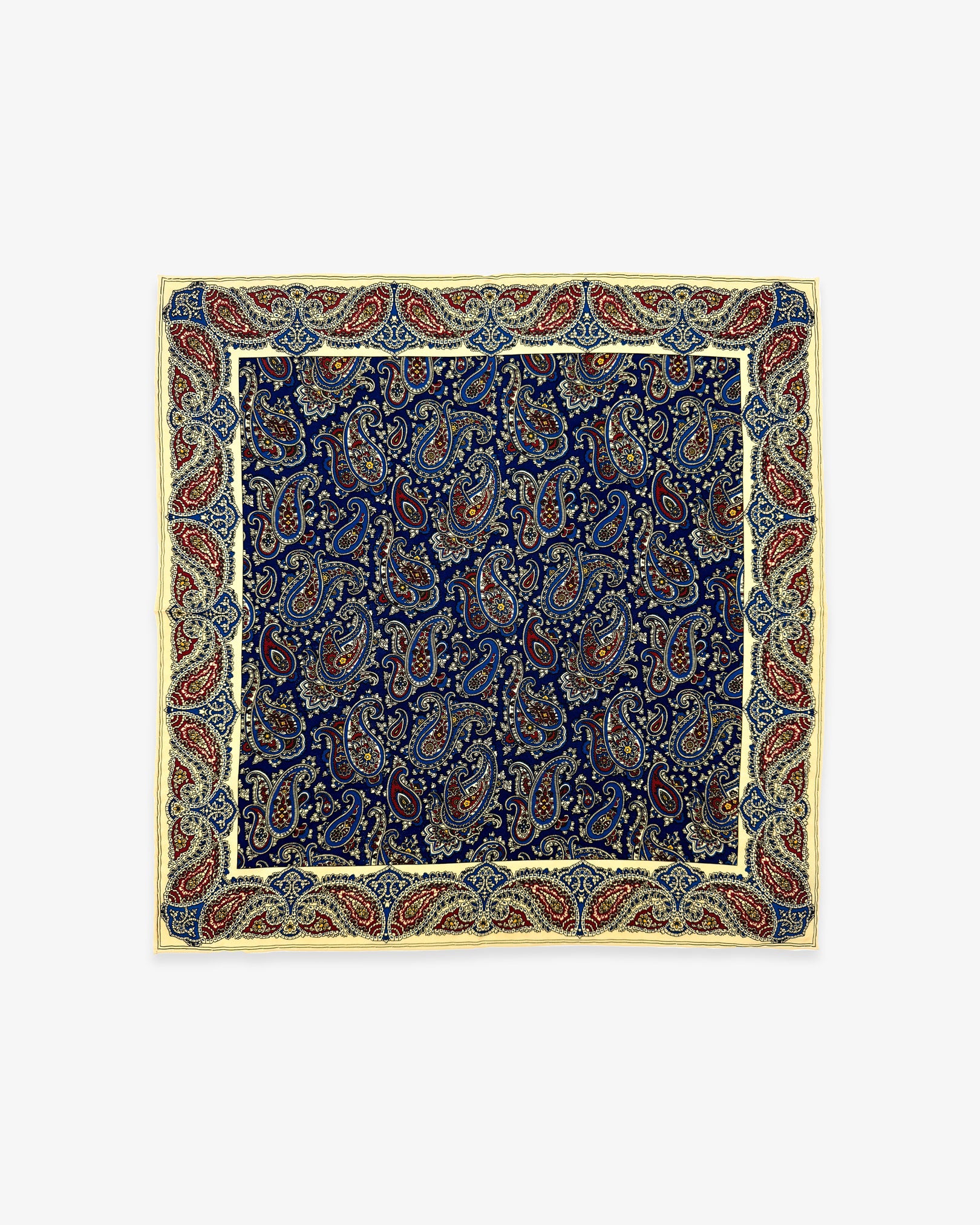 Fully unfolded 'Abbotsbury' English madder silk pocket square, showing the multicoloured swirls of paisley against a deep blue ground and attractive red and cream paisley frame.