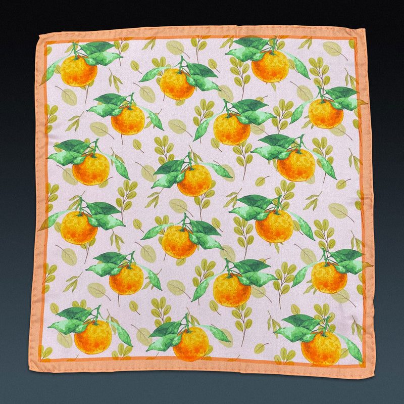 Fully unfolded 'Aire' silk pocket square, showing the classic mandarin orange motif, framed with a peach-coloured border.