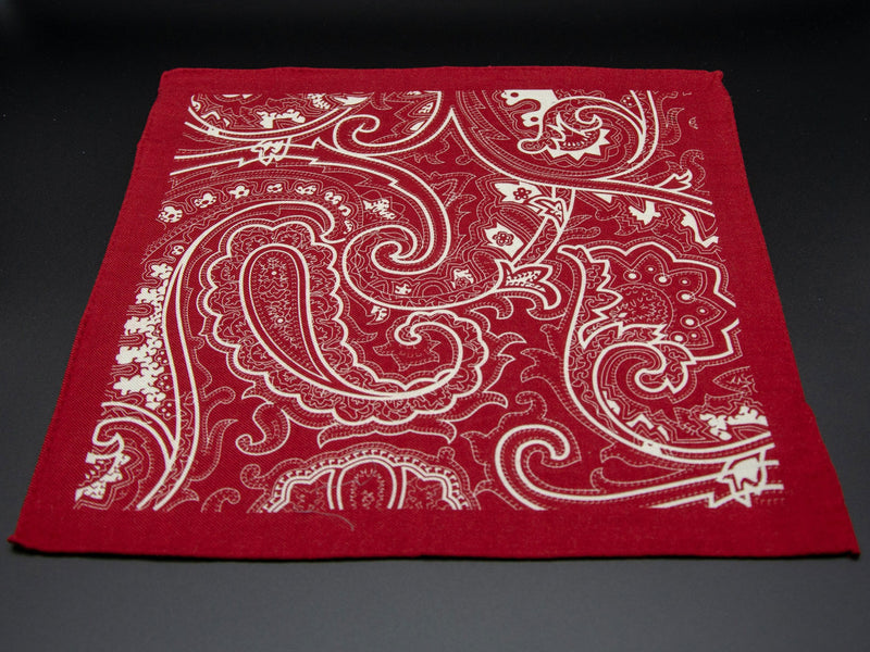 Fully unravelled wool 'Kalamaja' pocket square, showing the fluid paisley pattern framed by a matching red border.