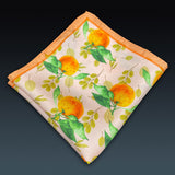 Folded 'Aire' silk pocket square from SOHO Scarves, showing the attractive orange and leaf pattern.