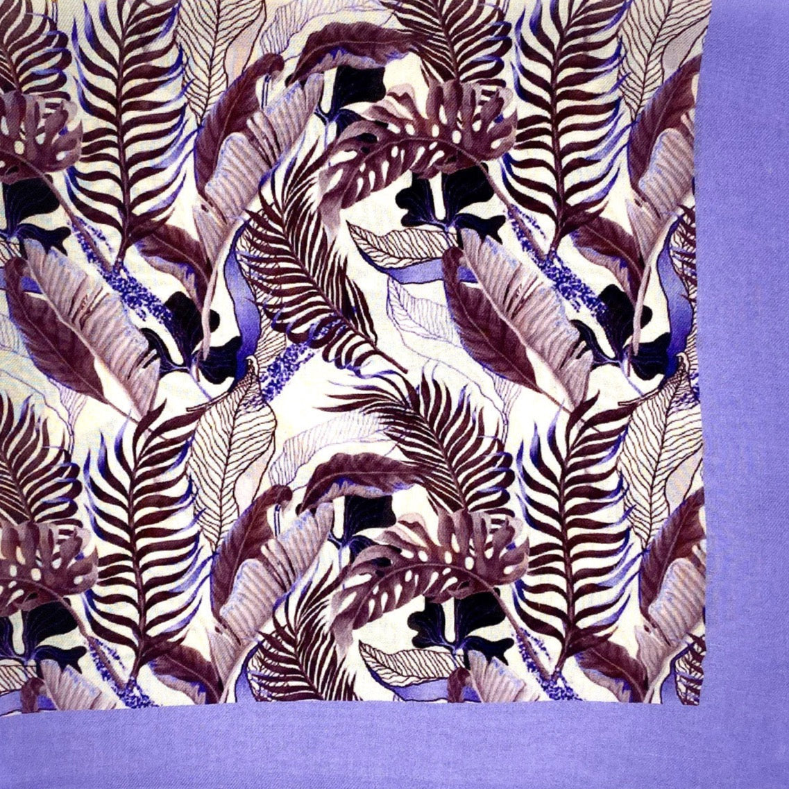 A flat, folded view of 'The Andes' bandana. The pattern is comprised of leaf and foliage shapes in various maroon and purple shades against a violet border.