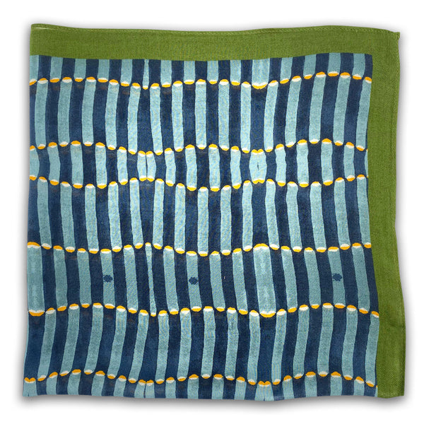 A flat, folded view of 'The Alps' bandana. The pattern shows the repeating pill-shaped patterns in blue, neatly framed with a green background.