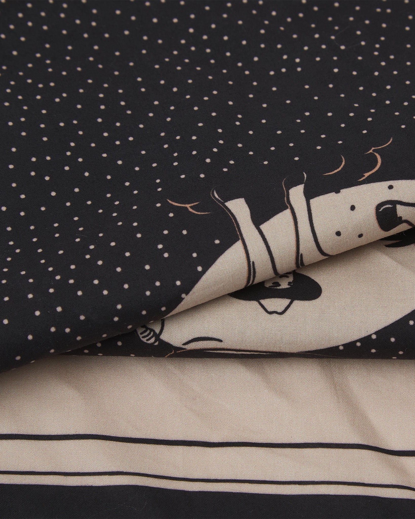 A ruffled, close-up view of the monochrome black and cream 'Integrity' Old West-style bandana from Soho Scarves.