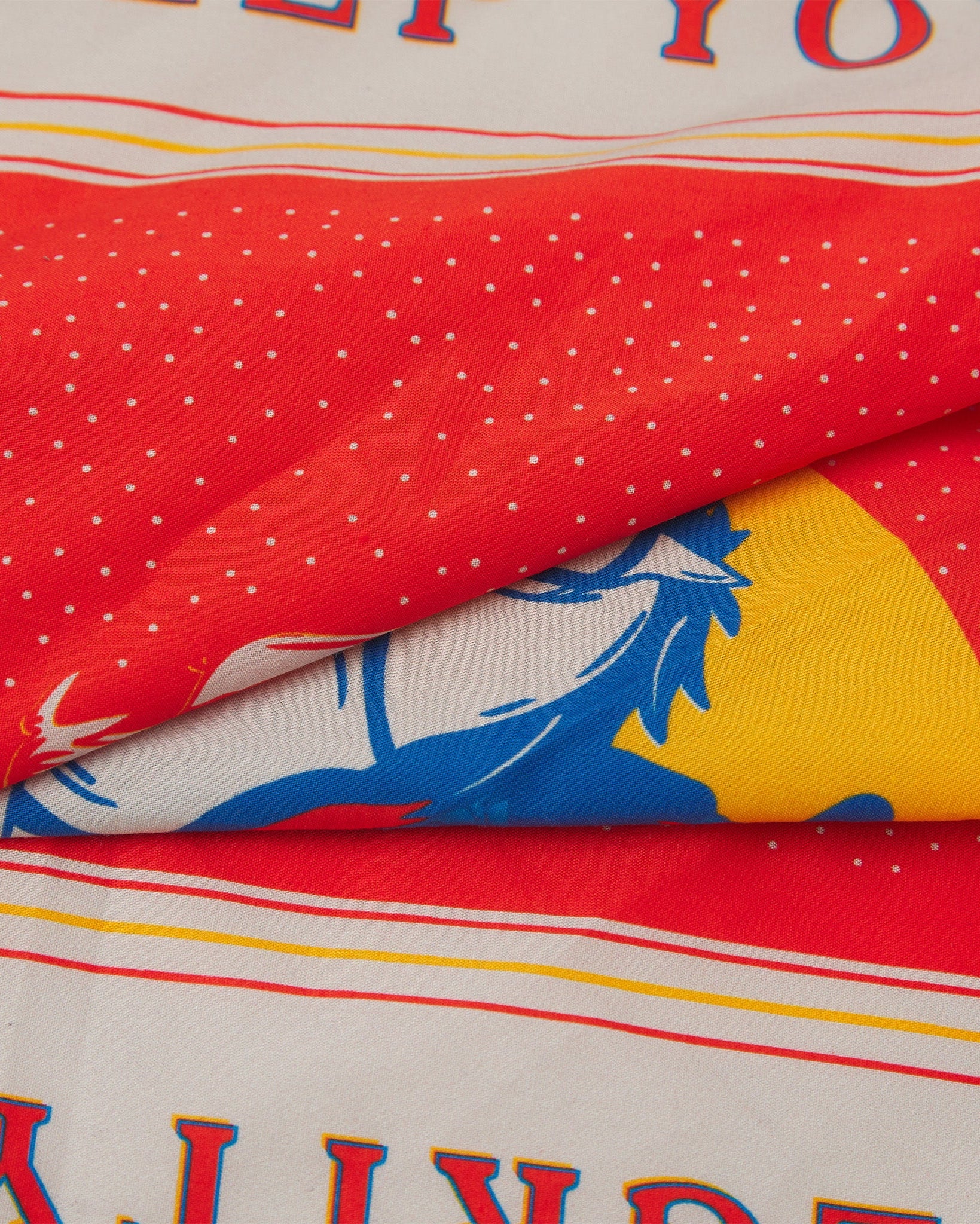 A ruffled, close-up view of the red, blue, yellow and white 'Integrity' Old West-style bandana from Soho Scarves.