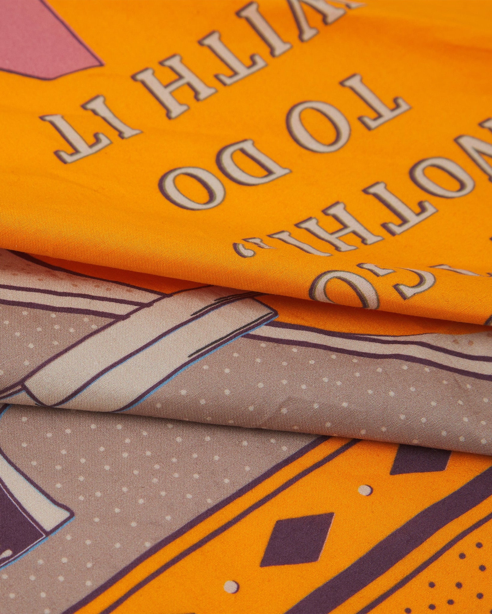 A ruffled, close-up view of the brown, orange and pink 'Luck' Old West-style bandana from Soho Scarves.