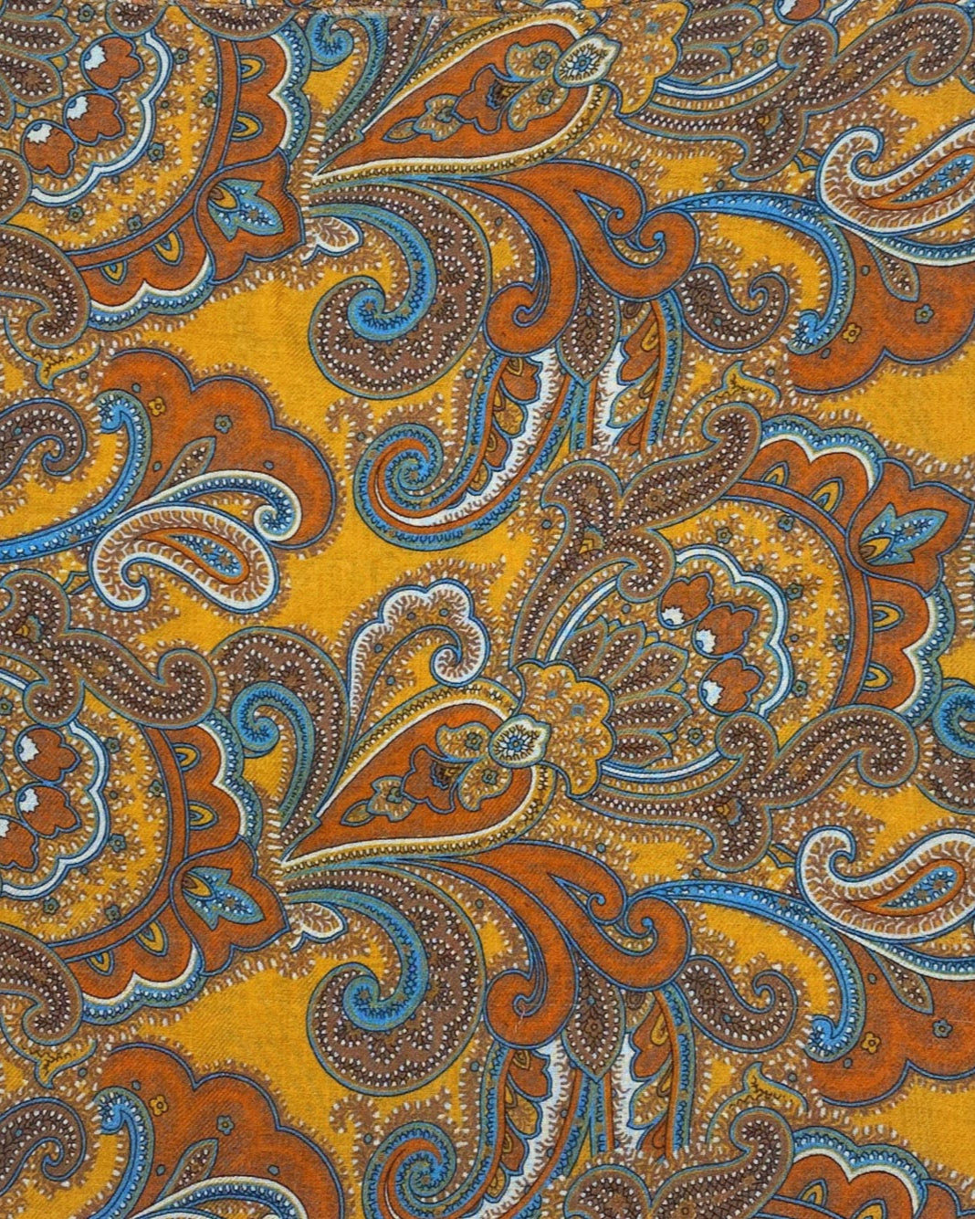 A flat, folded view of 'The Carnaby' boho wide scarf. Clearly showing the large swirls of paisley patterns on a gold-yellow background.