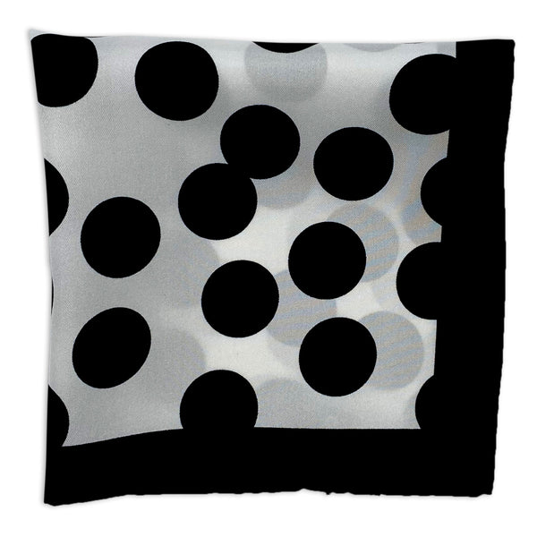 Chaney silk pocket square folded into a quarter, showing black polka dots on a white background, neatly framed with a black border.