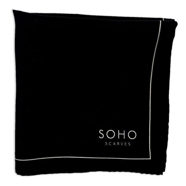 Chaplin silk pocket square folded into a quarter, showing the black block, neatly framed with a thin white border and 'Soho Scarves' logo.