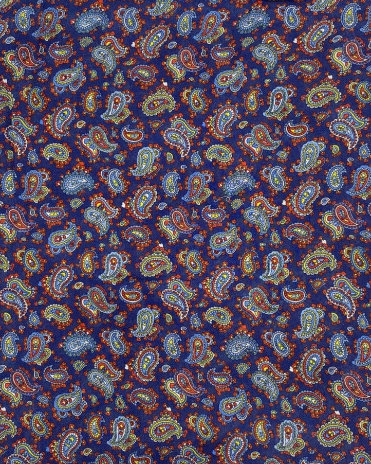 A flat, folded view of 'The Lexington' bandana. Clearly showing the intricate multicoloured paisley patterns on a midnight blue background.