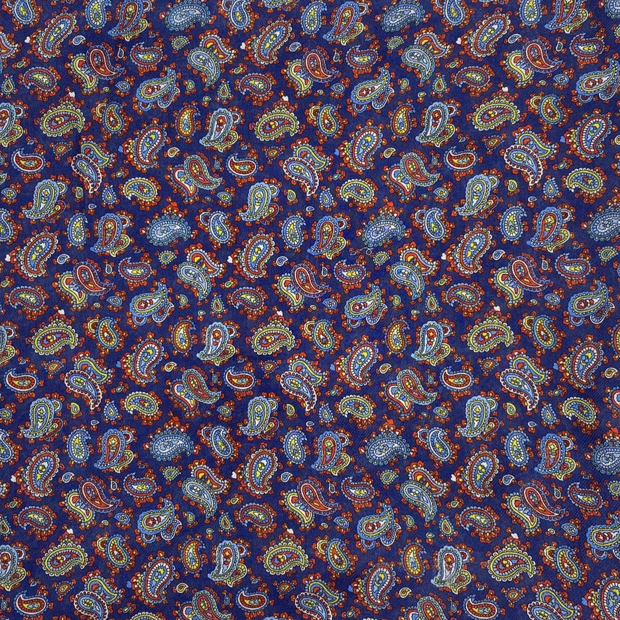 A flat, folded view of 'The Lexington' boho wide scarf. Clearly showing the intricate multicoloured paisley patterns on a midnight blue background.