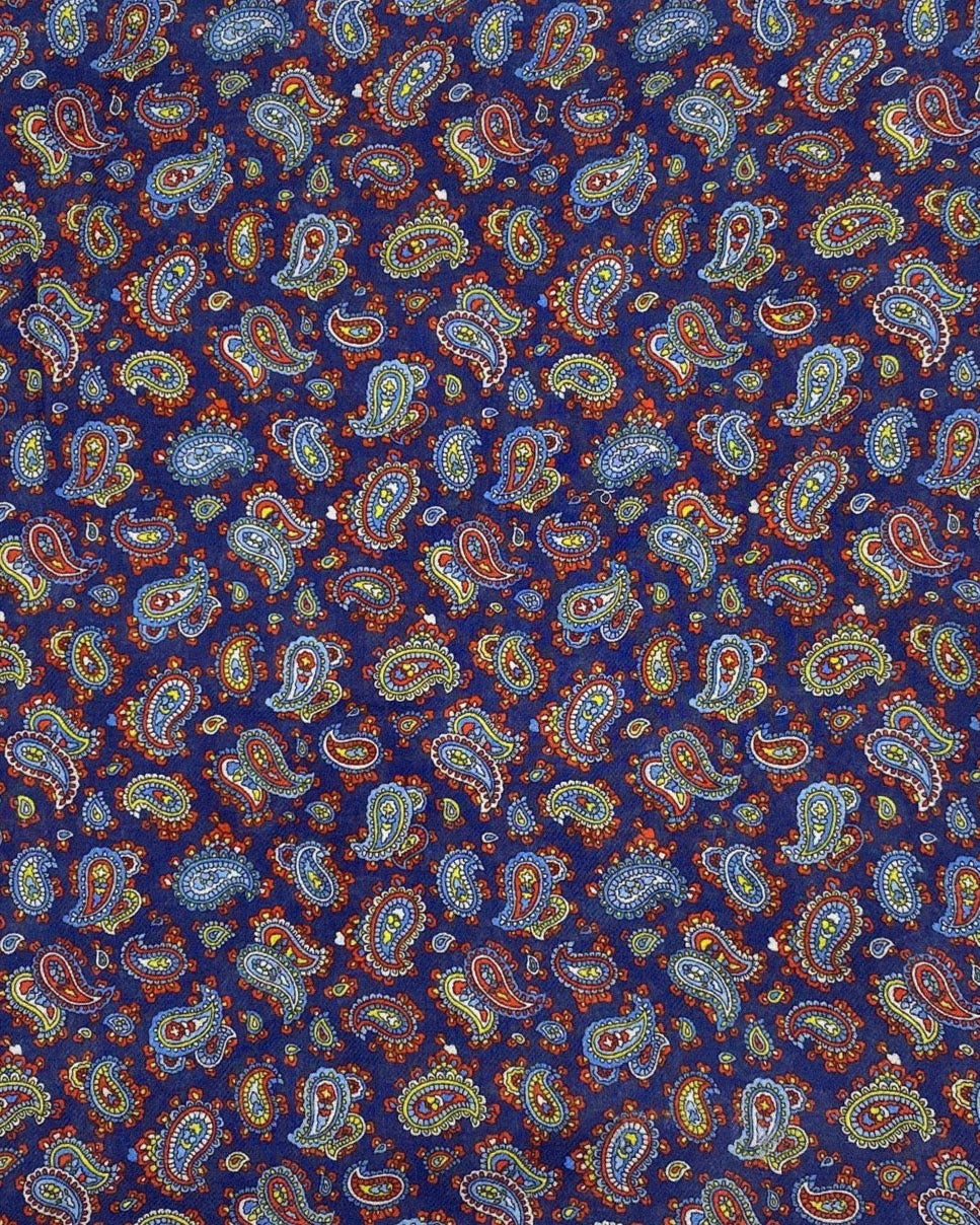 A flat, folded view of 'The Lexington' boho wide scarf. Clearly showing the intricate multicoloured paisley patterns on a midnight blue background.