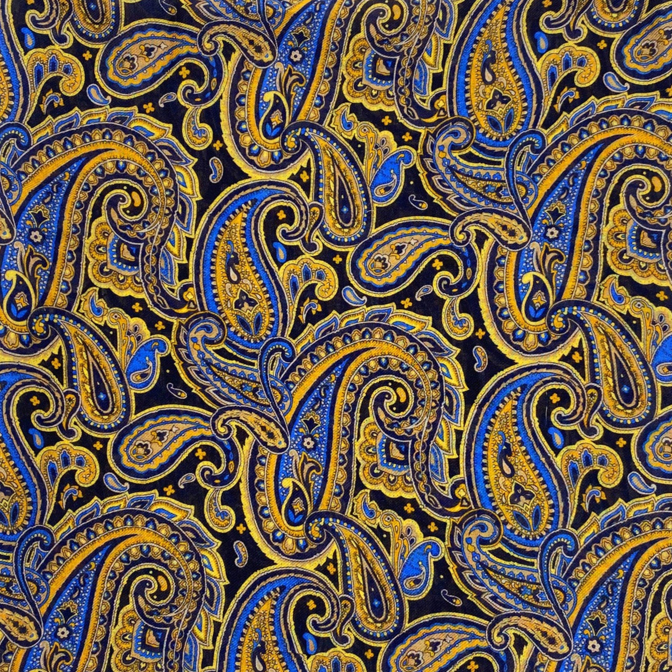 A flat, folded view of 'The Ormond' boho wide scarf. Clearly showing the intricate paisley patterns in blue, yellow and gold on a black background.