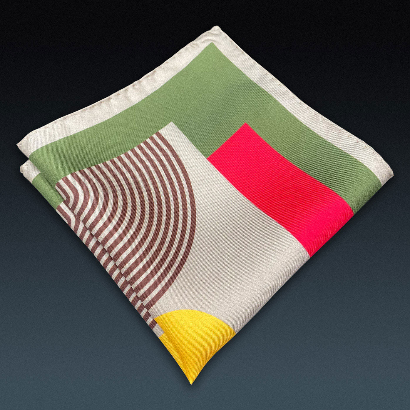 Folded 'Tay' silk pocket square from SOHO Scarves, showing the retro geometric pattern. Placed on a dark background.