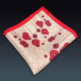 Folded 'Thames' silk pocket square from SOHO Scarves, showing the red poppy flower motif with matching border.