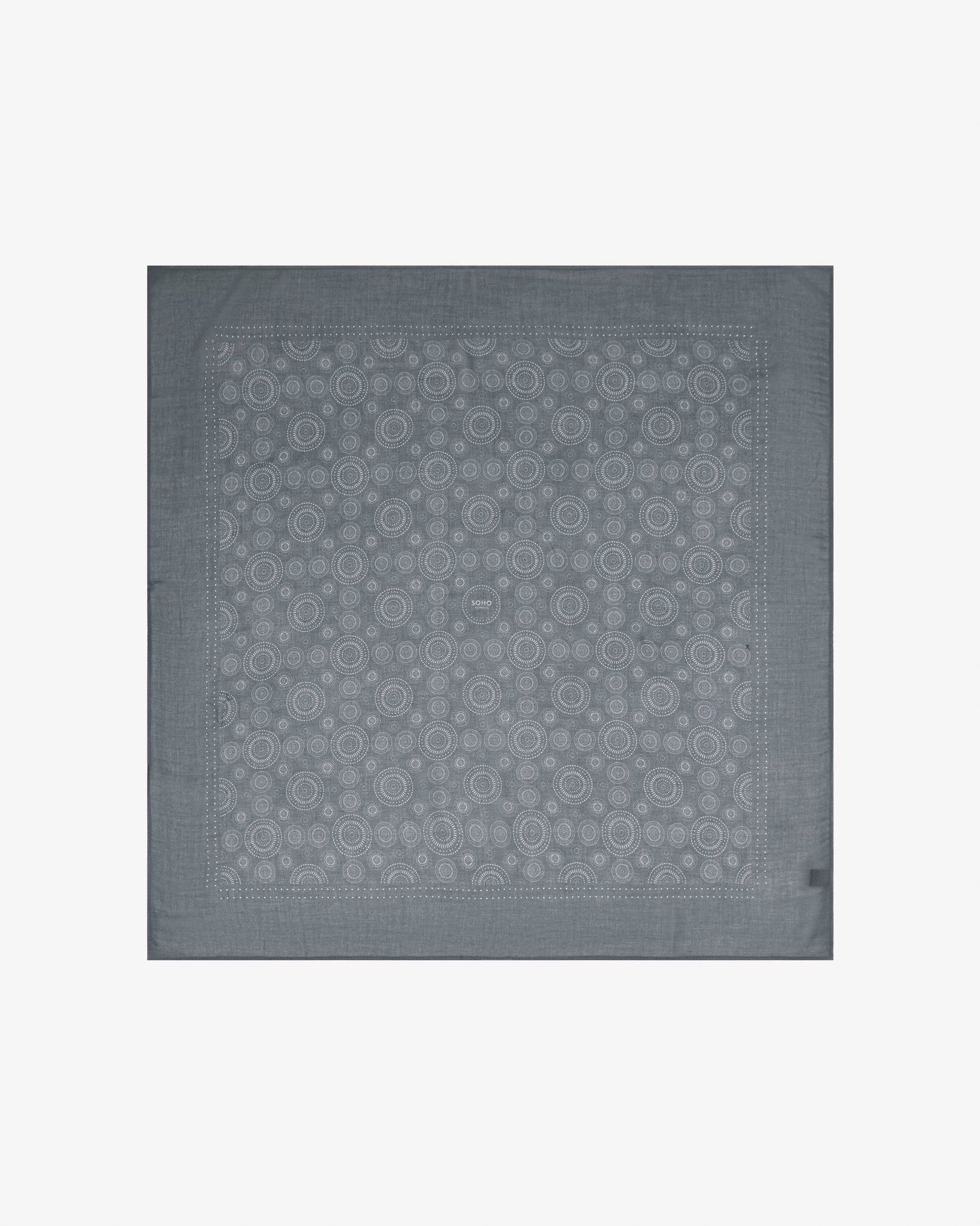 Fully unfolded 'Circles in Graphite' modal and wool bandana, displaying the complete repeating pattern of concentric Op art-inspired disc motifs in graphite grey tones framed by a wide border.
