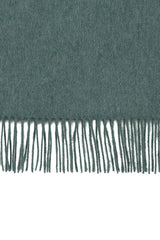 Perfectly horizontal view of the fringe of a green pure cashmere scarf from Soho Scarves against a white background.