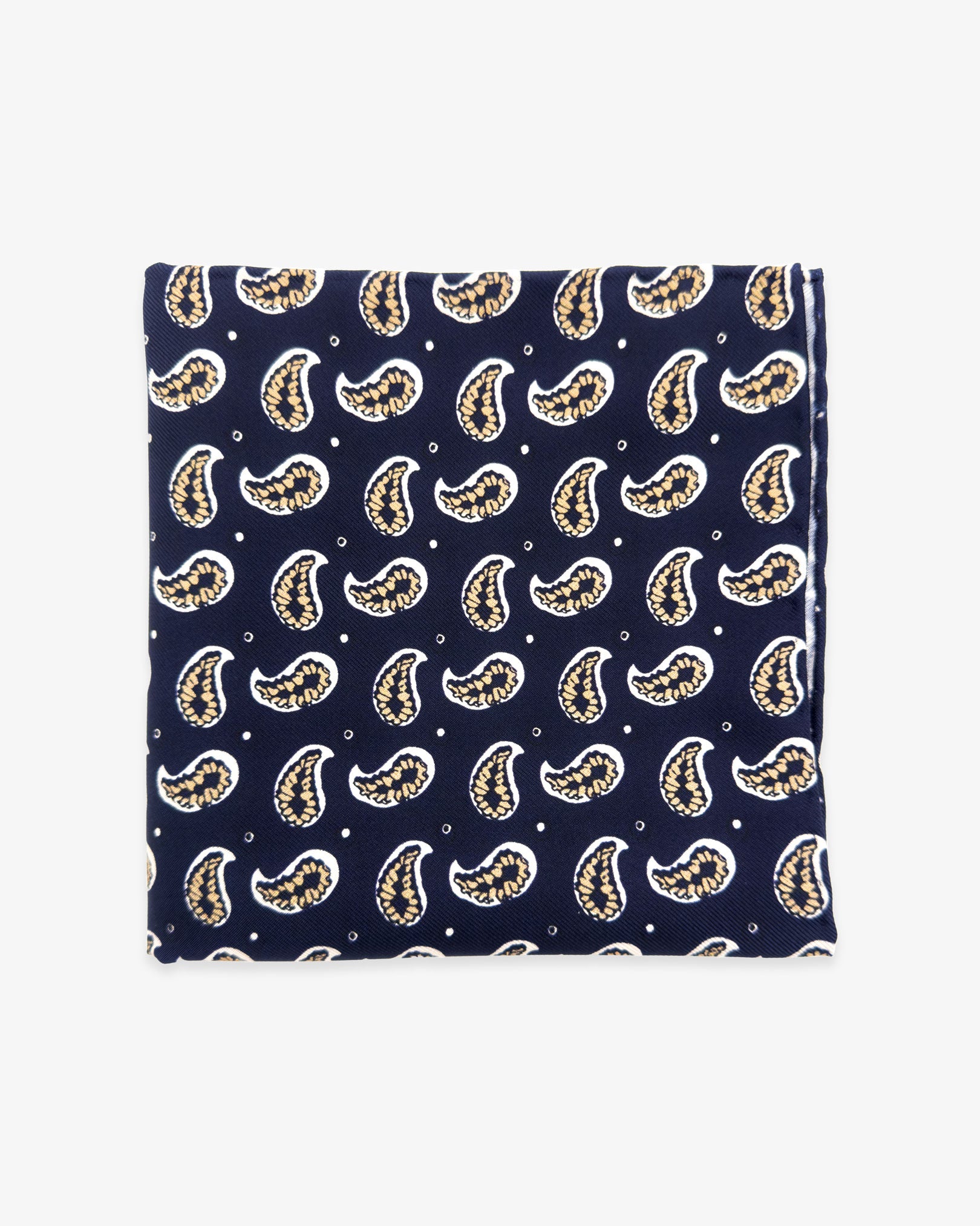 The 'Hadrian' silk pocket square from SOHO Scarves UK collection. Folded into a quarter, showing the stylised paisley patterns against a navy background.