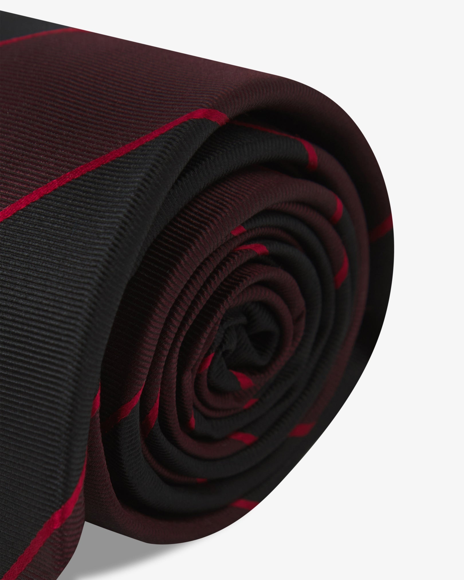 The 'Jarrett Good Fortune' silk neck tie neatly coiled with a clear view of the silk weave and maroon and black bandswith red pinstripes.