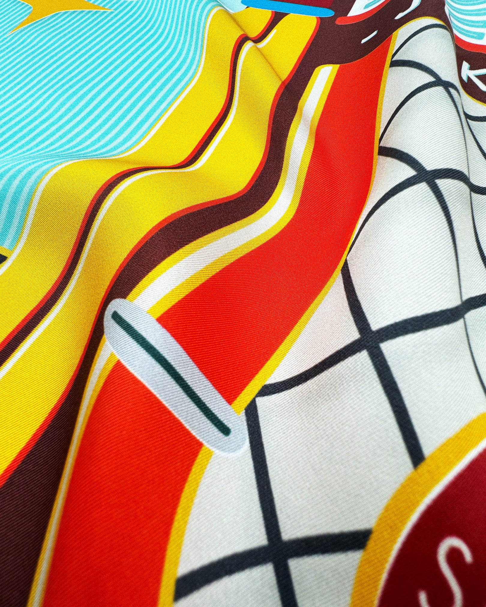 A ruffled close-up of the 'Jukebox 2' neckerchief, presenting a closer look at a the bold colours of the 1950's jukebox and the material's subtle lustre.