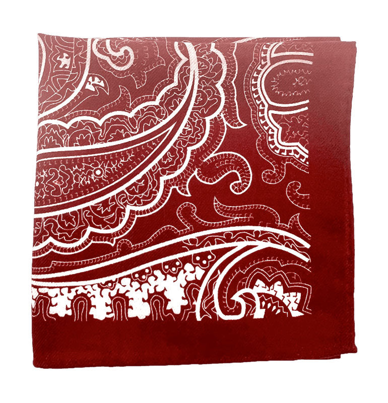 The 'Kalamaja' wool pocket square from SOHO Scarves folded into a quarter, showing the skeletal white paisly forms against a deep red ground.