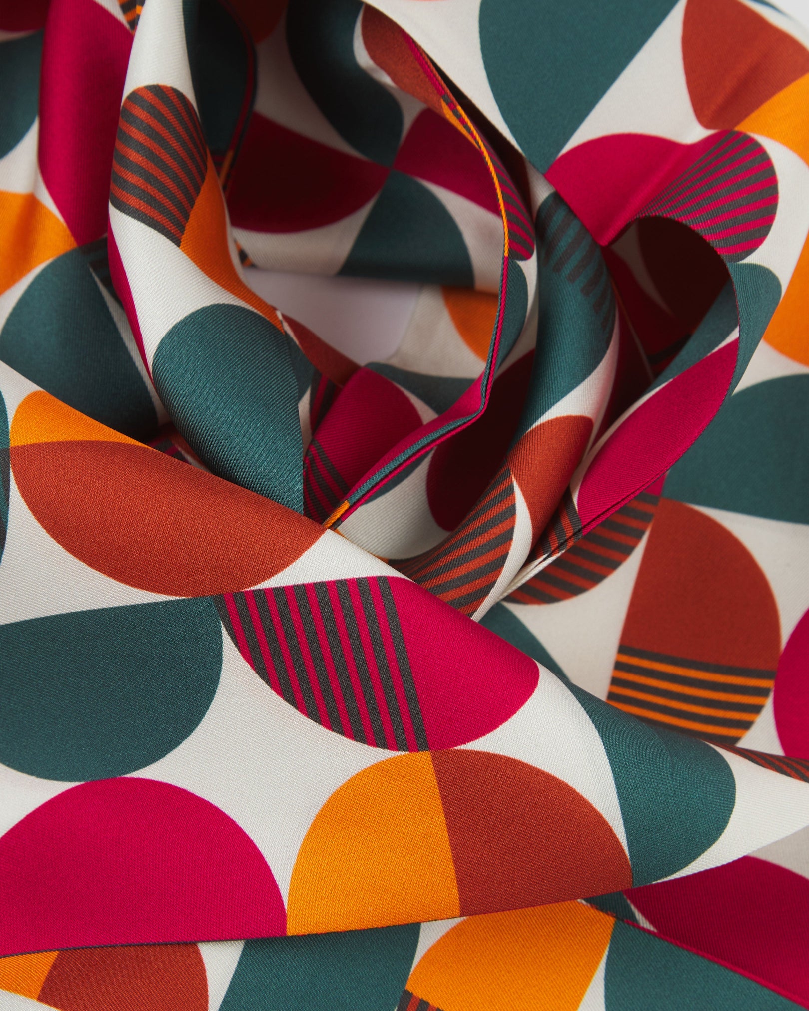 A ruffled close-up of the 'Kassel' silk scarf, presenting a closer view of the multicoloured, Bauhaus inspired patterns.