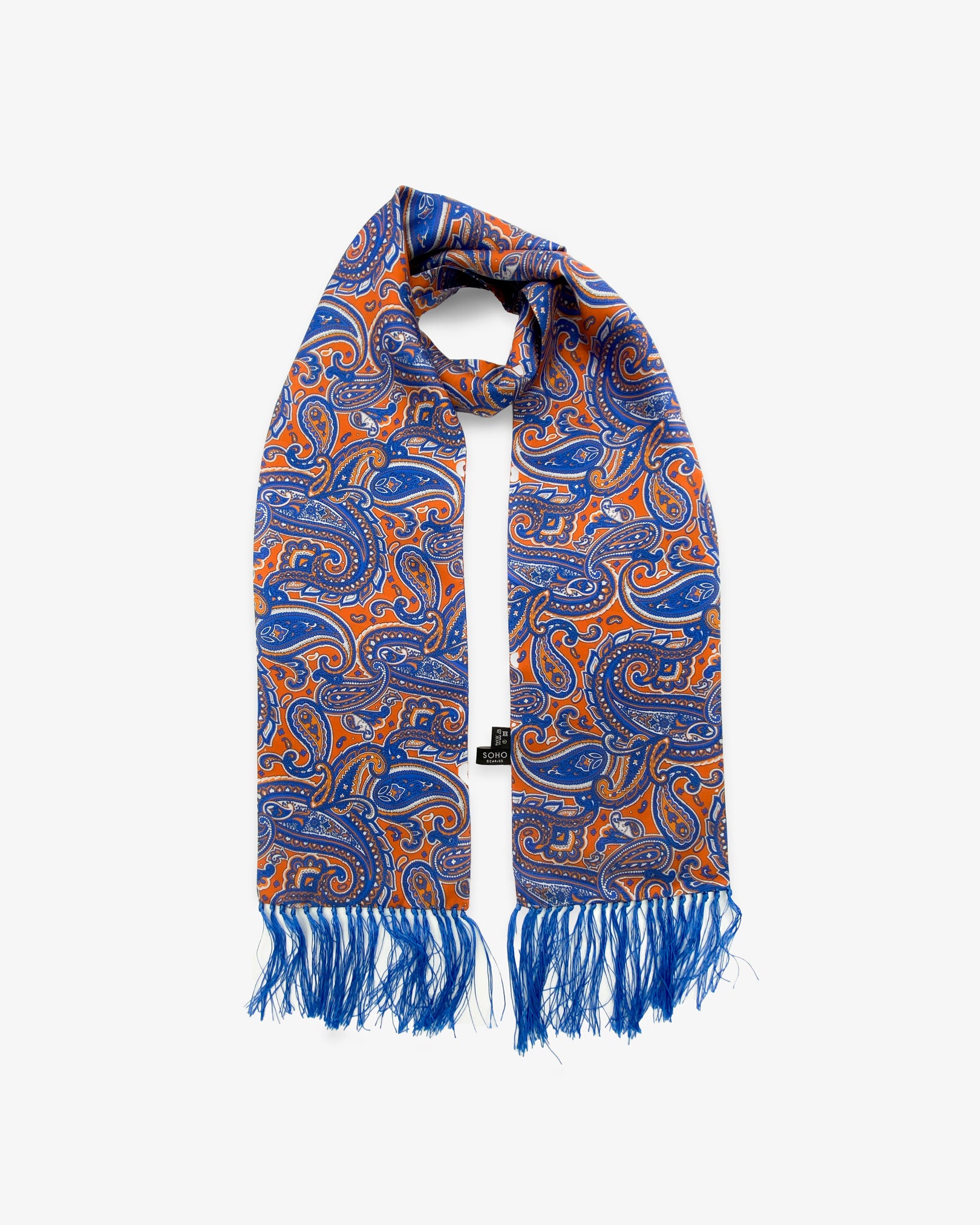 Orlando aviator scarf looped in middle with both ends parallel showing the blue and orange paisley patterns on a vibrant orange ground with clear view of 3 inch blue fringe.