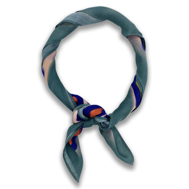 The Cascade bandana knotted into a loop, showing the brightly coloured modal-wool fabric.