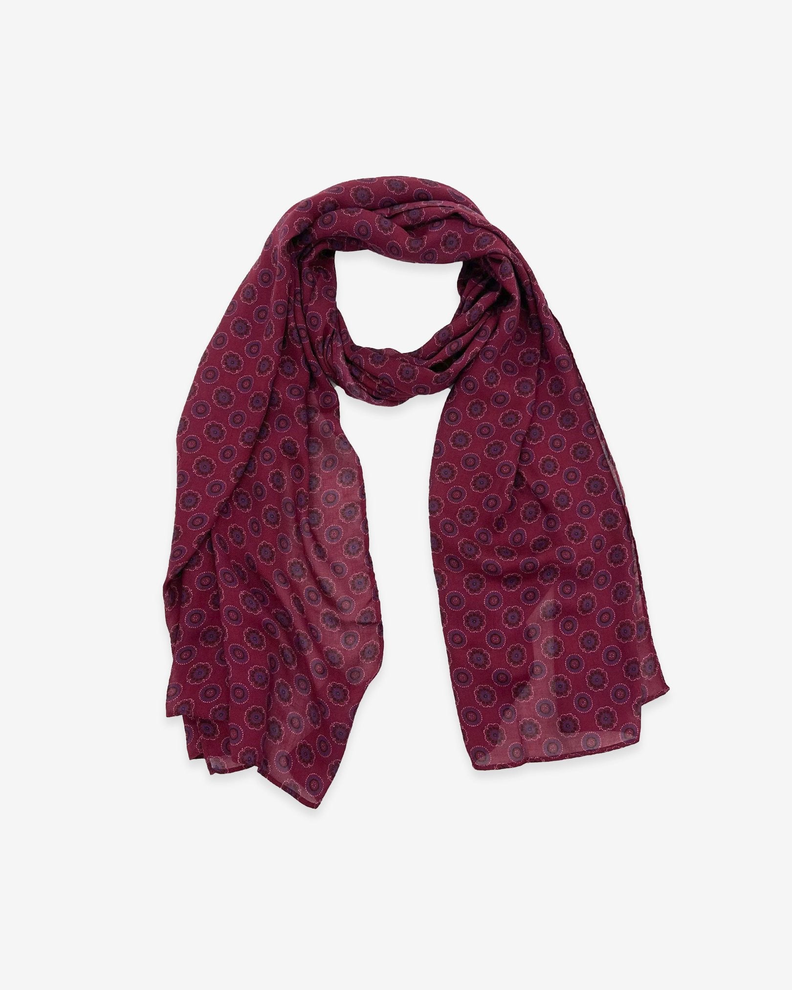 The Seattle wide scarf unravelled and looped in the middle, demonstrating the considerable length and showing the floral and circular patterns on a maroon ground.