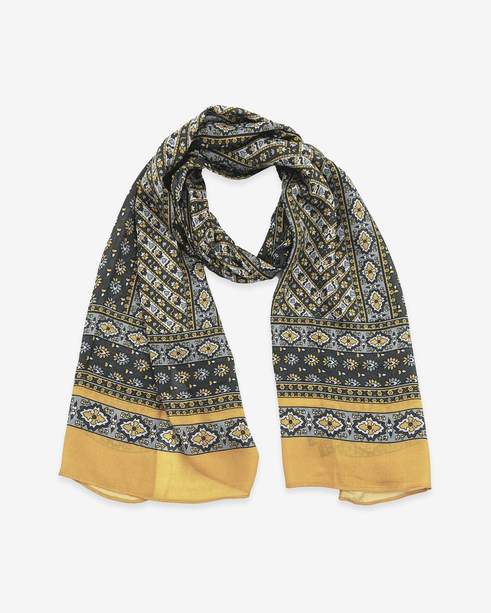 The Whitehorse wide scarf unravelled and looped in the middle, demonstrating the considerable length and showing the floral-inspired patterns in yellow, grey and silver.