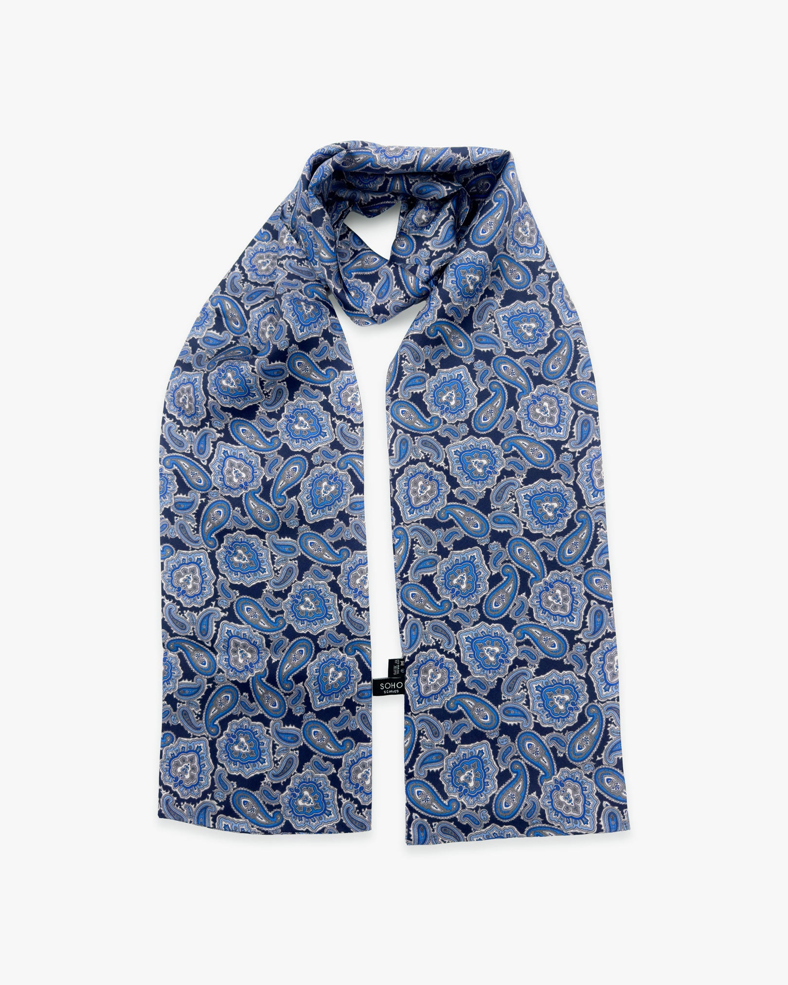 The Dezon pure silk scarf looped in middle with both ends parallel showing the blue paisley patterns.
