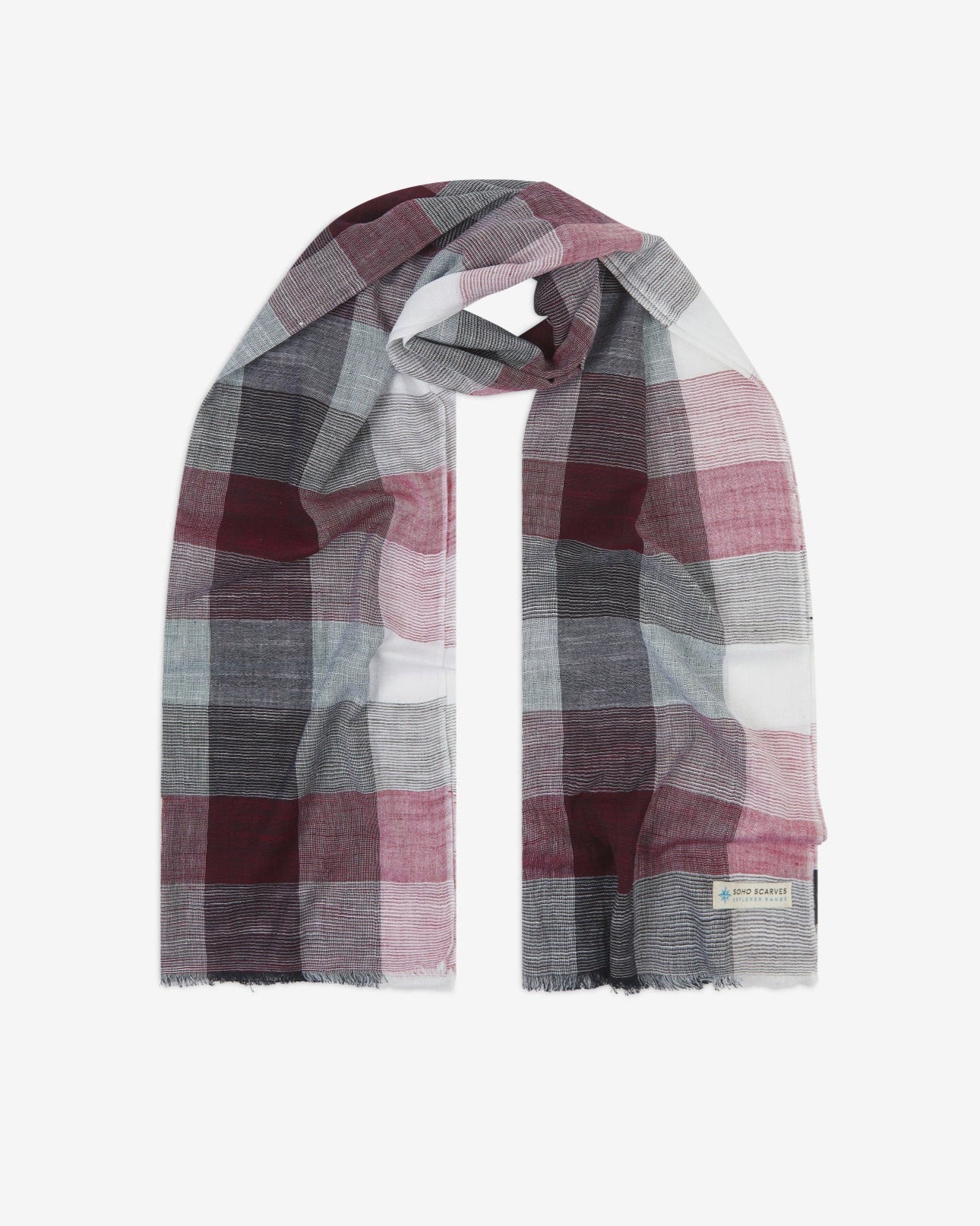 The 'Fiennes' cotton plaid scarf, looped in middle with both ends parallel. Displaying the checkered pattern of greys, pinks, and whites and the SOHO Scarves Explorer Range branding logo in the bottom-right.