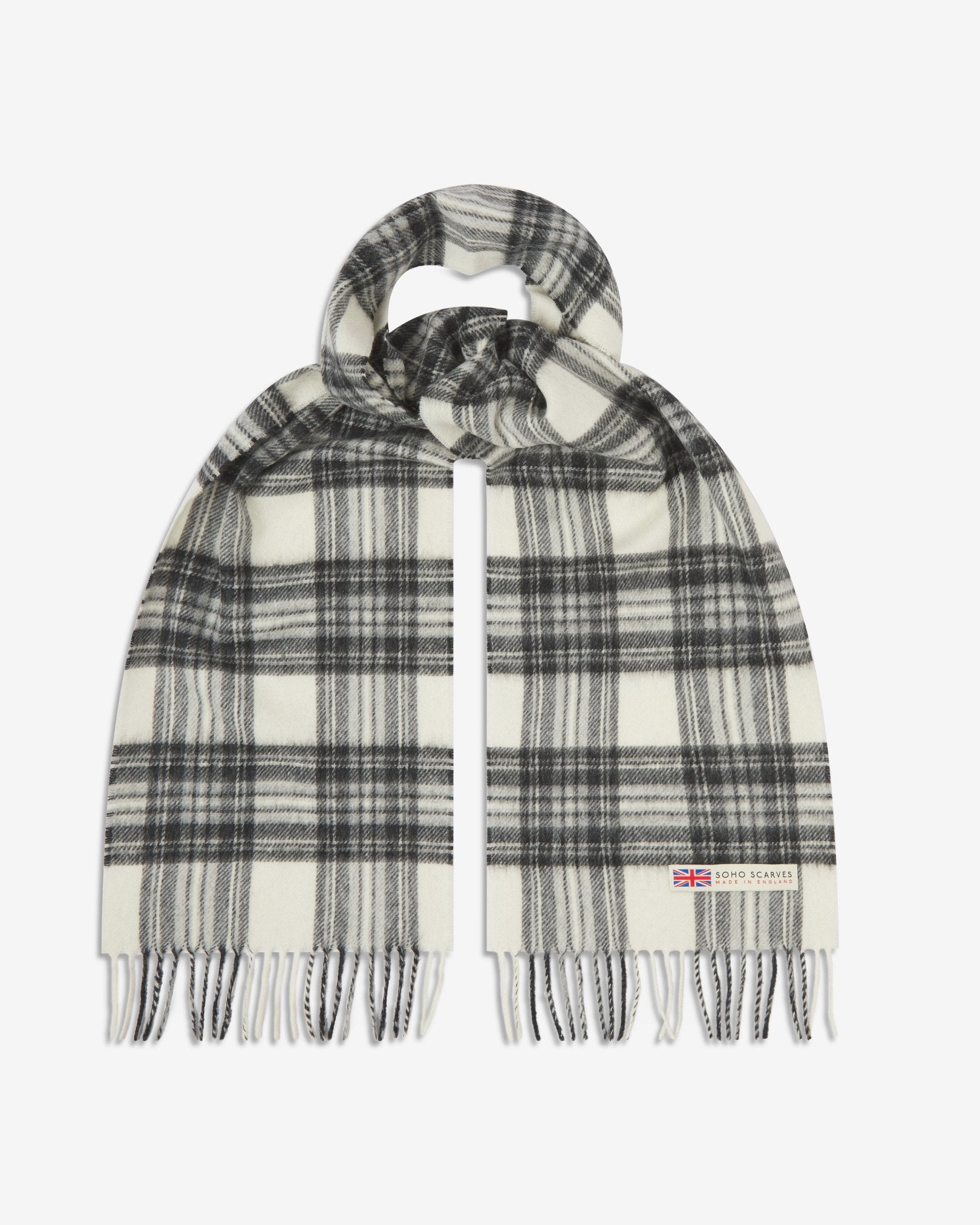 The 'Highlands' tartan in grey scarf, looped in middle with both ends parallel showing the black, white and grey patterns, fringing and SOHO Scarves logo with Union Jack motif.