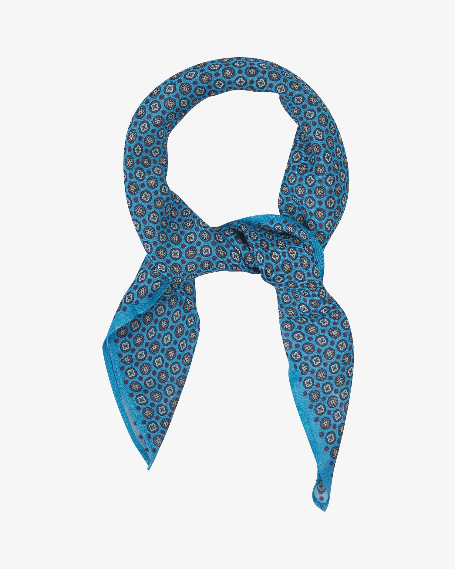 The Toshima Gardenia bandana knotted into a loop, showing the  repeat pattern of multicoloured stylised floral patterns patterns on a blue background.