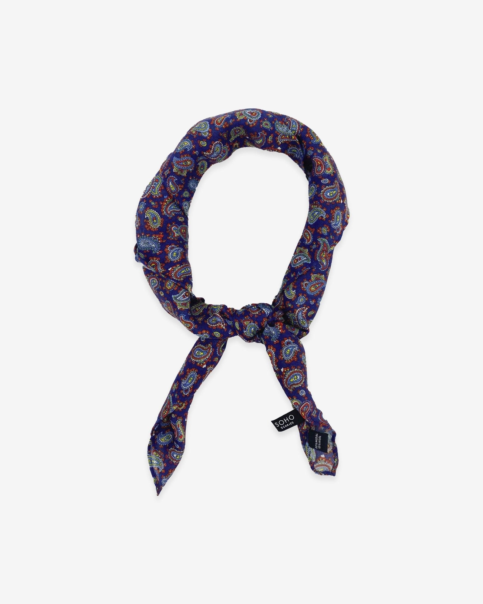 'The Lexington' light blue, gold and white paisley patterned bandana on a dark purple-blue background. Knotted into a loop on a white background.