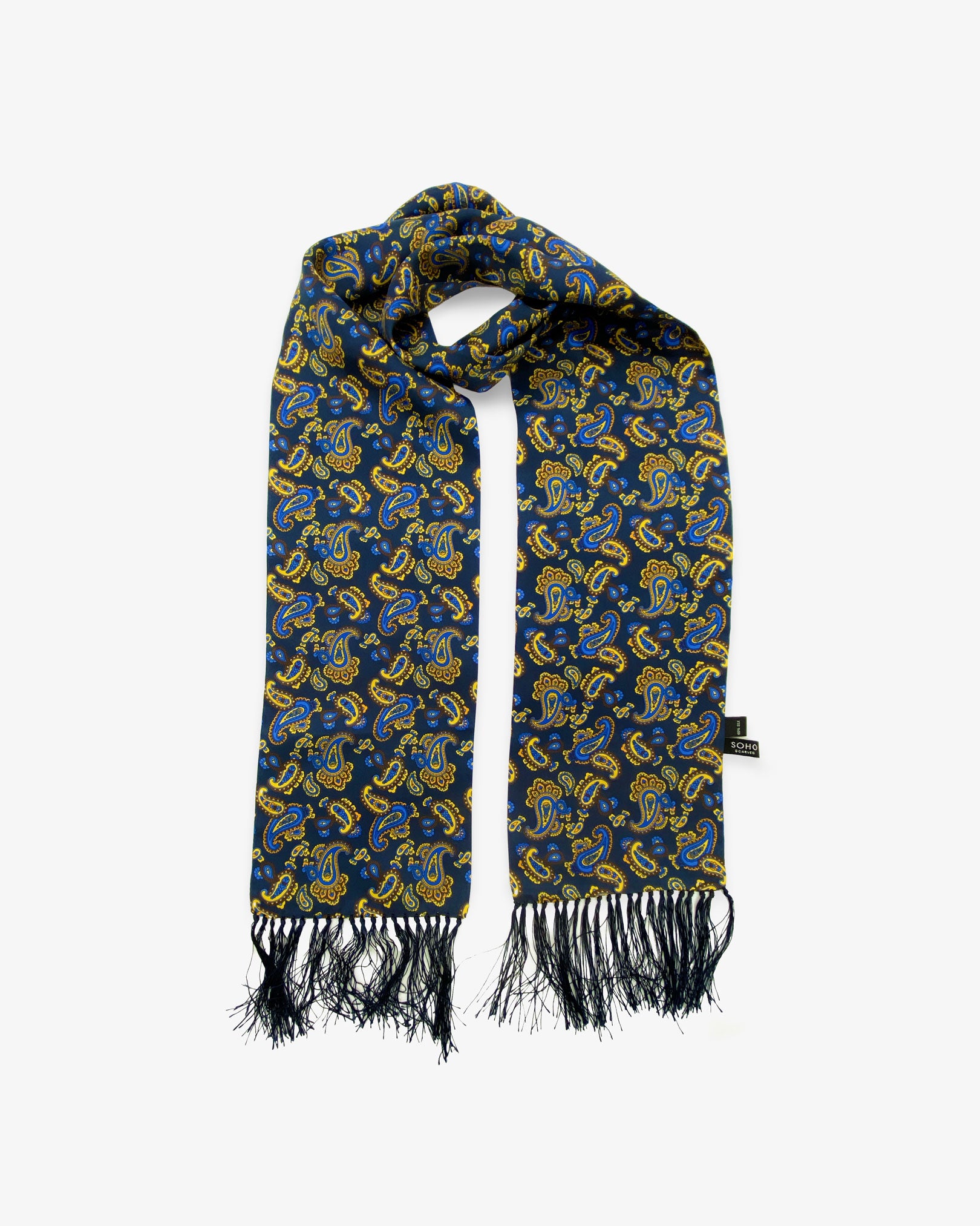 The Lucie pure silk aviator paisley scarf looped in middle with both ends parallel showing the intricate swirls of blue and yellow paisley on a deep blue ground with matching 3-inch fringe.